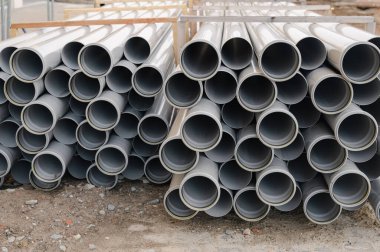 Şehir sokağının yakınındaki tamir edilmiş boru yığını, kentsel bakım sürecini gösteriyor.