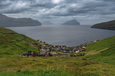 Engebeli yeşil kayalıklar, Faroe Adaları 'nın vahşi kıyı şeridi boyunca Atlantik Okyanusu' na yaklaşıyor..