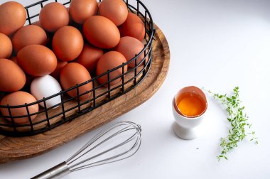 Organik tavuk ve bıldırcın yumurtaları beyaz iç kısımda metal sepette sergilenir..