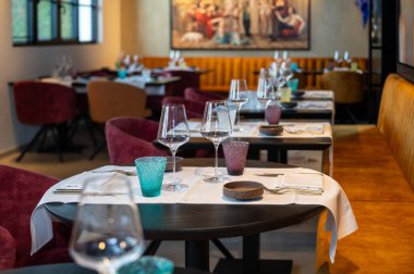 Kutlama masası, çoklu yer ayarları, renkli taklalar, sıcak ziyafet koltukları.