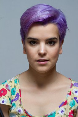 Camer gülümseyerek mor kısa saçlı kadın