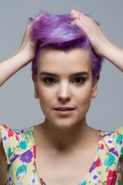 Saçları iki eliyle tutan Menekşe kısa saçlı kadın