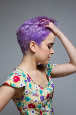 Menekşe saçını tutan kısa saçlı bir kadın profili