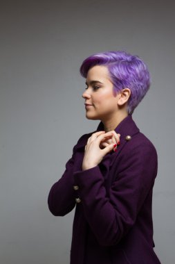 Menekşe kısa saçlı kadın mor bir palto giyiyor elele bir