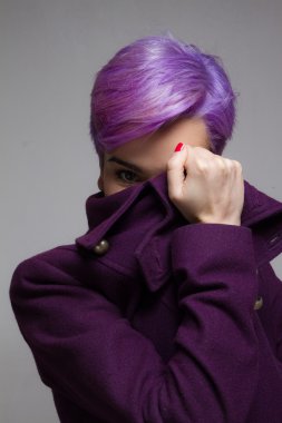 Menekşe kısa saçlı kadın bir viol arkasında bir göz ile bakmak