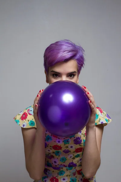 Violeta de cabelos curtos segurando um balão com as duas mãos — Fotografia de Stock