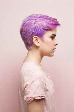 Pembe hamur içinde mor kısa saçlı bir kadın profili