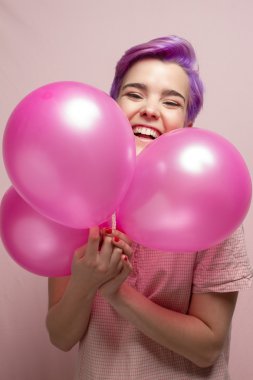 Pembe pastel balon gülüyor Menekşe kısa saçlı kadın