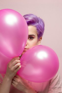 Pembe pastel balonlar bakmak Menekşe kısa saçlı kadın