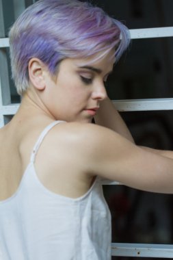 Bir çit yaslanmış bir menekşe kısa saçlı kız görünümünü arka geçmek