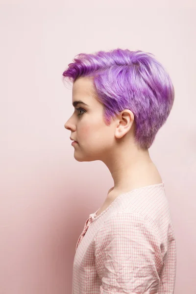 Pembe hamur içinde mor kısa saçlı bir kadın sol profili
