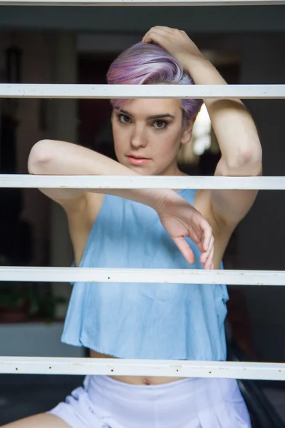 Eine schöne violette kurzhaarige Frau hinter einem Fechter — Stockfoto