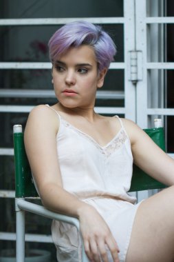 Menekşe kısa saçlı kız açık havada onun sağ seyir oturmuş