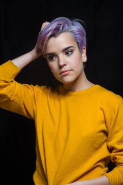 Onu tutan bir sarı kazak giyen Menekşe kısa saçlı kadın 