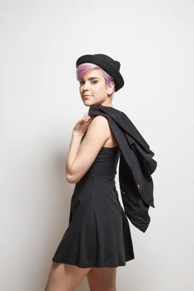 Violette kurzhaarige Frau mit Hut, die einen Mantel über ihrem Schal hält — Stockfoto