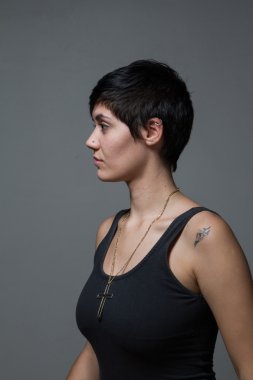 Profili bir siyah giyen bir kısa saçlı esmer kadın, kapalı alanda,