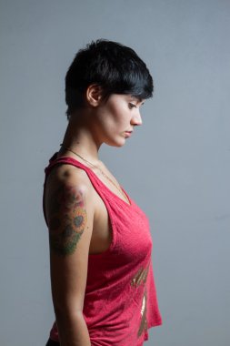 Kırmızı t giyen bir ayakta kısa saçlı esmer kadın profili