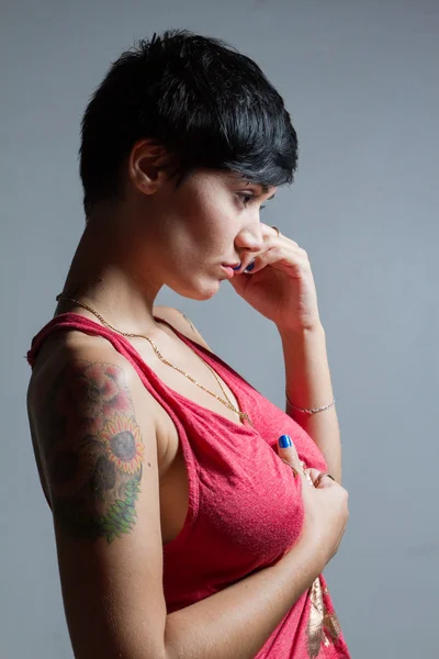 Kırmızı t giyen bir ayakta kısa saçlı esmer kadın profili