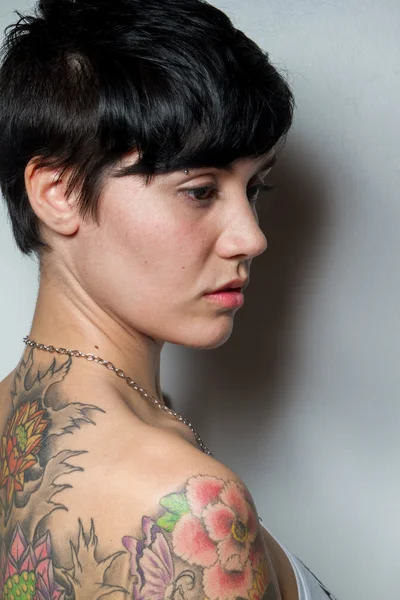 Bir dövme ile güzel bir kısa saçlı esmer kadının arkadan görünüş