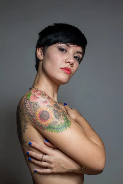 Гола короткошерста брюнетка обнімає себе татуюванням на — стокове фото
