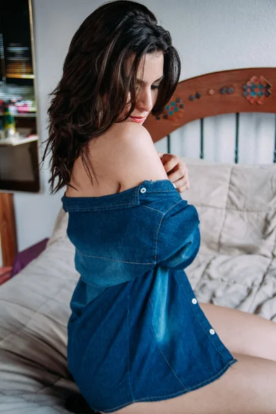 Sexy mujer de rodillas en la cama y se ve dow — Foto de Stock
