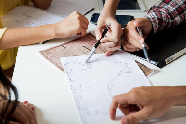 Mimari projesi ile çalışan birkaç el 