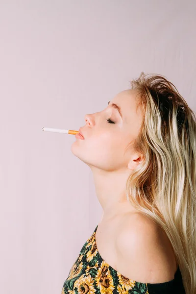 Профиль молодой блондинки с закрытыми глазами, курящей — стоковое фото