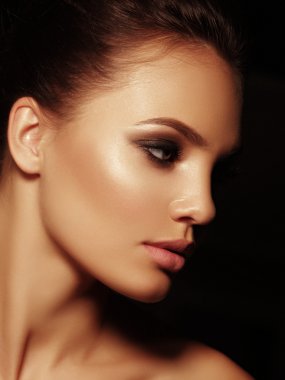 Elegant portrait of a sexy appealing naked brunette with full lips and closed smoky eyes on the black background clipart