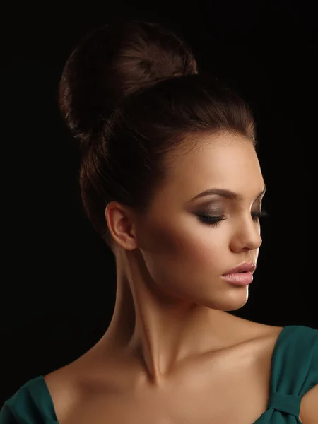Retrato romántico de una joven hermosa con rasgos suaves recogido pelo y maquillaje expresivo sobre el fondo negro —  Fotos de Stock