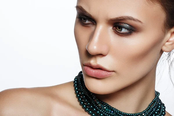 Elegante joven con maquillaje elegante noche y hermosas joyas collar en su cuello. Hermosa cara de mujer . — Foto de Stock