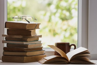 Kitap, su bardağı, gözlük penceresinde