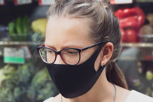 Portrait of a girl in a protective mask near food