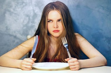 Woman waiting some food with an empty plate.