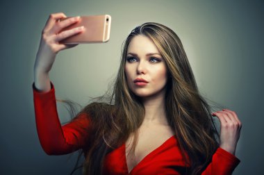 Smartphone üzerinde konuşmak mükemmel sevimli yüzü ile Kırmızı elbiseli kadın.