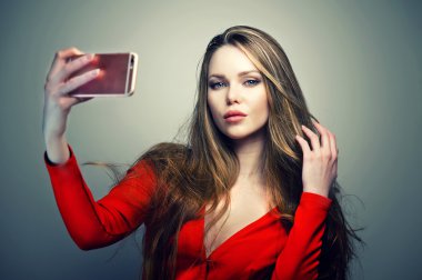 Smartphone üzerinde konuşmak mükemmel sevimli yüzü ile Kırmızı elbiseli kadın.