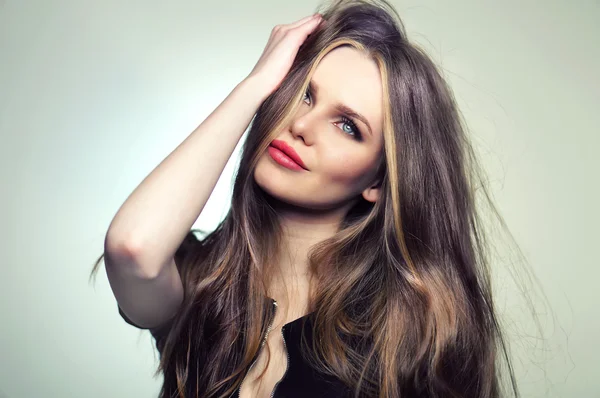 Frauenmodel mit tollen Haaren und Make-up, roten Lippen und tiefblauen Augen - posiert im Studio in der Softbox und blinkt. — Stockfoto