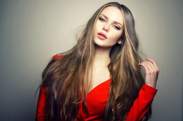 Sexy kaukasische Model mit tiefblauen Augen und empfindlichen Lippen posiert im Studio im Licht der Blitze. tolles langes natürliches Haar. — Stockfoto