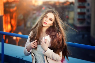 genç güzel zarif kız çatı günbatımında poz.