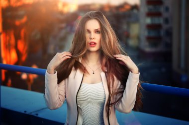 genç güzel zarif kız çatı günbatımında poz.