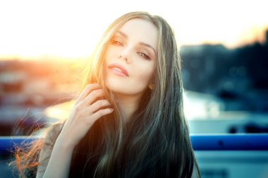 Şehvetli dudakları parlak günbatımı sonunda çatı poz kadınla.