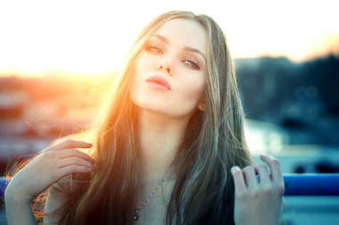 Şehvetli dudakları parlak günbatımı sonunda çatı poz kadınla.