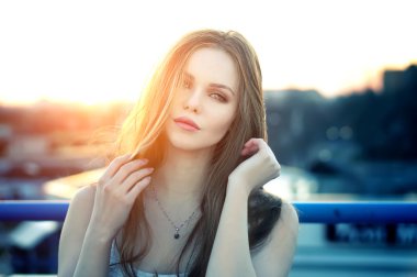 Şehvetli dudakları parlak günbatımı sonunda çatı poz kadınla.