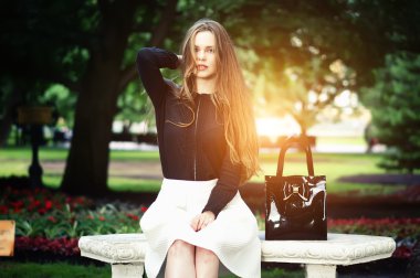 Güneşli bir günde dışarıda doğanın keyfini bankta oturma kadın.