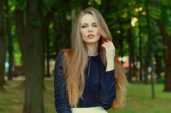 Сексуальная женщина с рыжими губами и большими волосами, наслаждающаяся своим временем на улице в парке . — стоковое фото