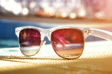 Havuzu yansıtan renkli Güneş gözlükleri