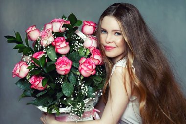 Beyaz elbiseli, güzel kız bir sepet buket gül tutan