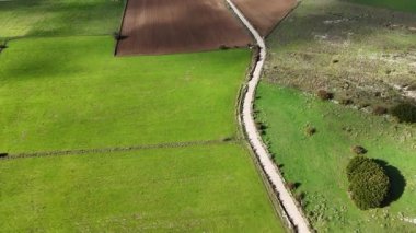 Bir dağ vadisindeki tarlaların ve yolun havadan görünüşü.