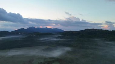 Gün doğmadan önce bir dağ vadisinde sabah sisinin havadan çekilmiş görüntüsü..