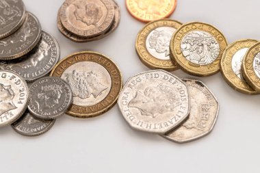 Beyaz üzerine izole edilmiş çeşitli gevşek Sterling sikkeleri kapatın.