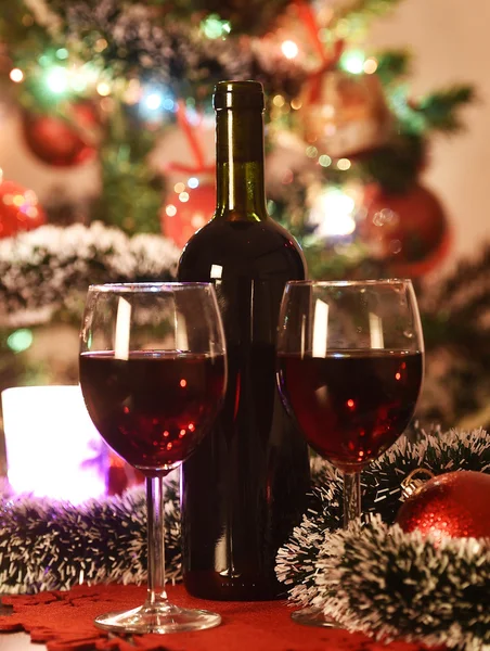 Glasses with wine in front of an illuminated Christmas tree — Stock Photo, Image